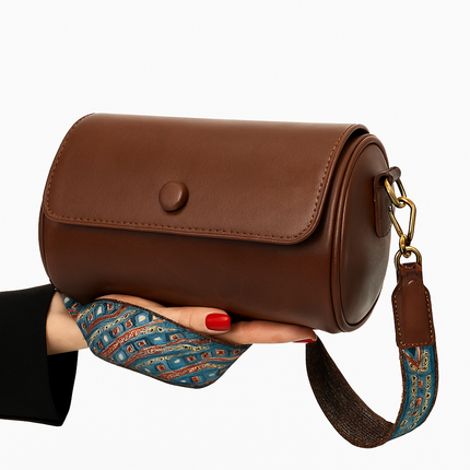 Sleek Brown Cylinder Bag with Artistic Strap Accent