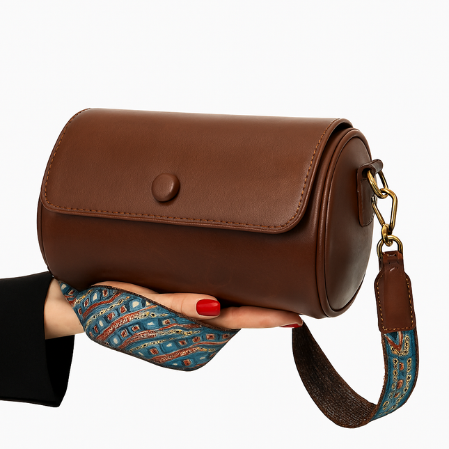Sleek Brown Cylinder Bag with Artistic Strap Accent